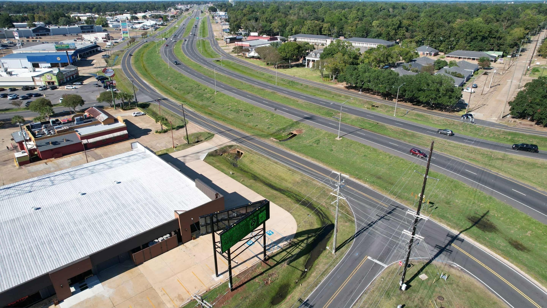 Aerial view of Presteaux Promotions billboard along busy highway in Alexandria, LA